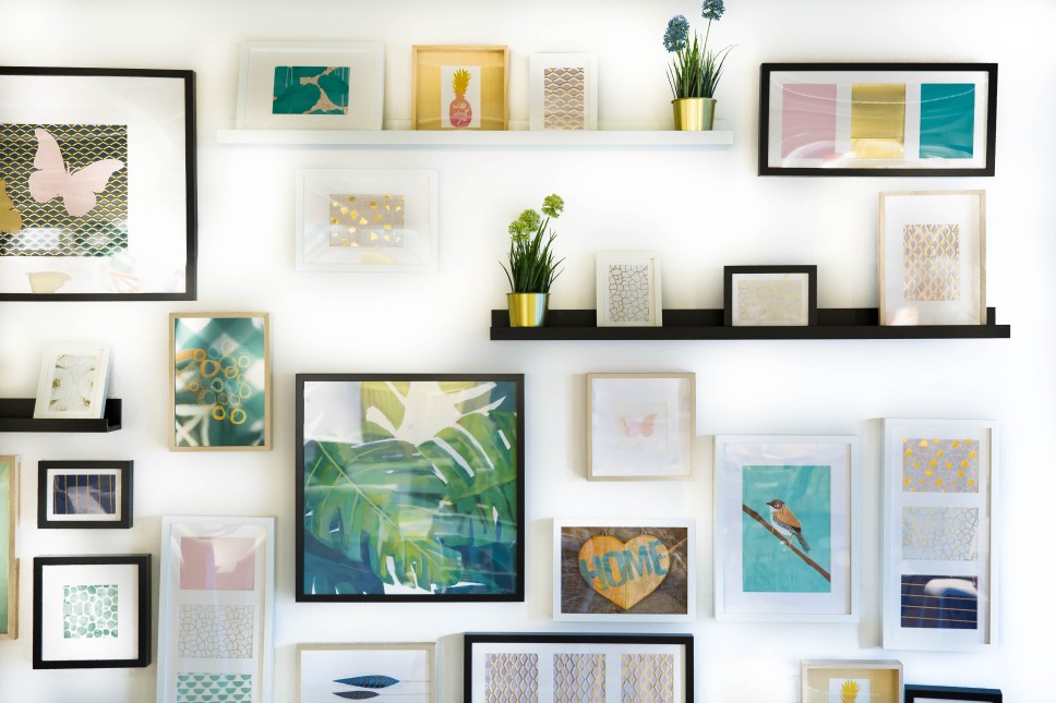 Image of a white wall in a home with multiple pictures on the wall