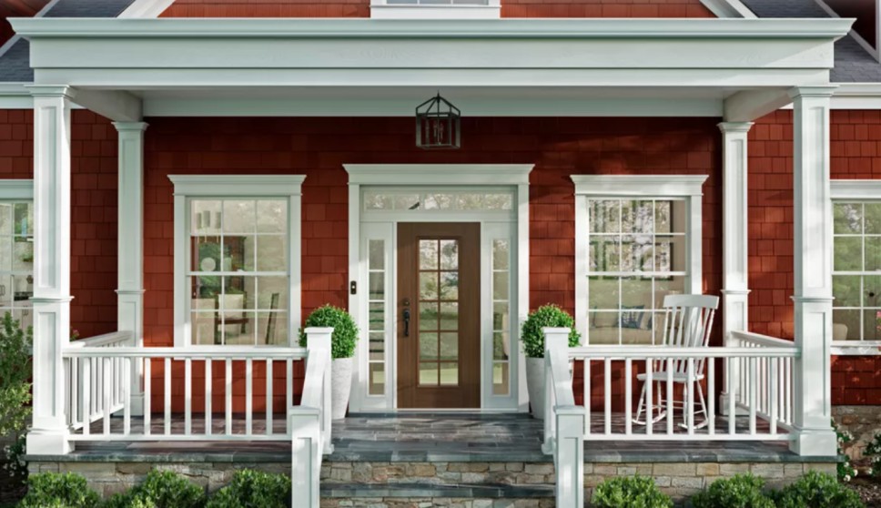 Front porch with an entry door, transom windows, and white fencing.